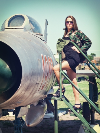 Beautiful young woman getting ready to get in an old fighter bomberのeditorial素材