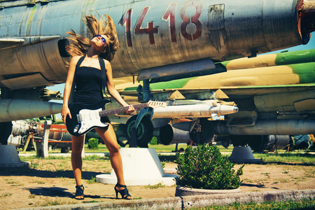 Vintage style photo from a beautiful young woman playing on her bass guitar のeditorial素材