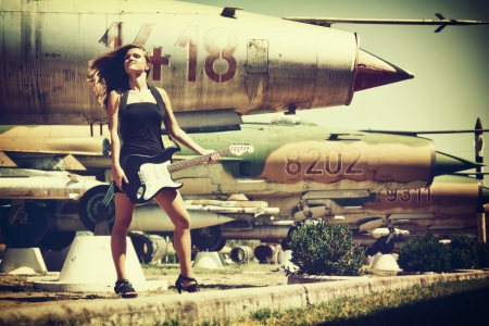 Vintage style photo from a beautiful young woman playing on her bass guitar のeditorial素材