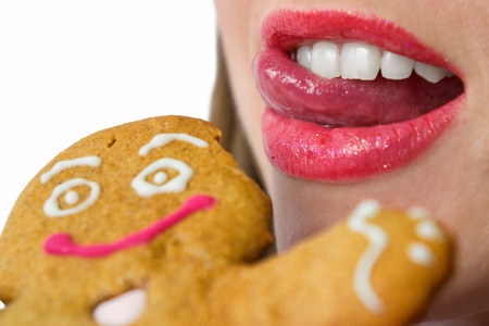 young women eating a gingerbeard figureの写真素材
