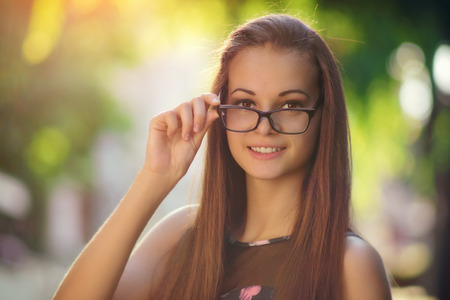 Outdoor photos from the beautiful young women in eyeglasses, in the city parkの写真素材
