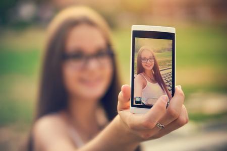 The selfie Young girl take a picture with herself with a mobileの写真素材