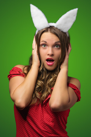 Beautiful young woman in bunny ears surprisedの写真素材