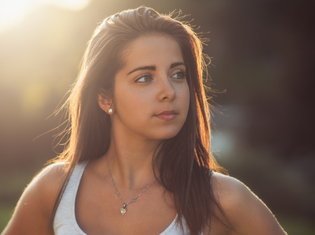 Outdoor photos from a beautiful young woman, sunset in the backgroundの写真素材