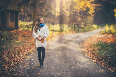 Young beautiful woman walking in the forest at autumnの写真素材