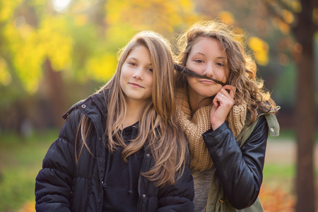 Two young teenager in the city park at autumnの写真素材