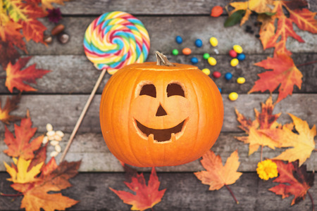Halloween candies with pumpkin and autumn leafsの写真素材