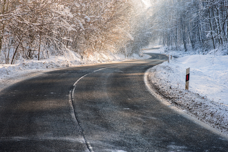 Frosty, slippery road in the deep forest at winterの写真素材