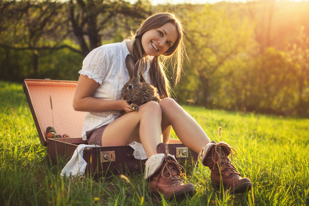 Friendship with an Easter Bunny / Vintage style photo from a beautiful young woman with her bunny,の写真素材