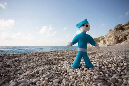Blue stuffed doll, photographed on the beachの写真素材