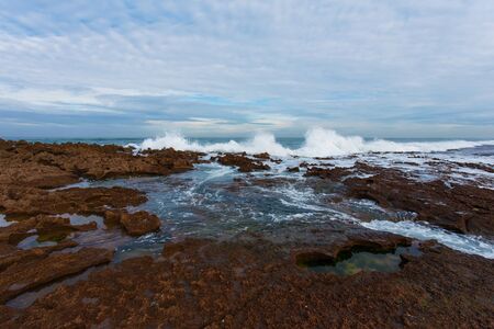 Waves breaking on a rocky seashore at the Atlantic ocean in Moroccoの写真素材
