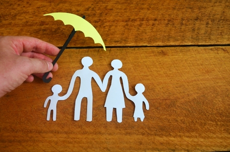 Paper family protected by an umbrella.