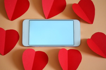 Cellphone surrounded by red hearts.