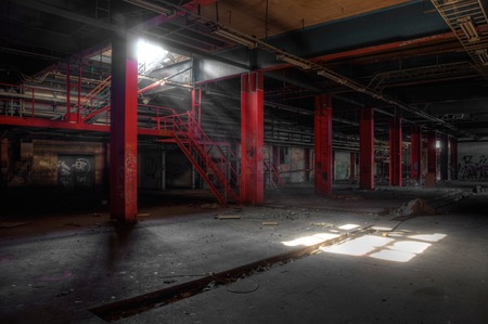 Light shines in a deserted hall with red steel girdersのeditorial素材