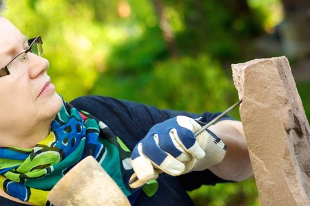 Female stonemason at work in the gardenの写真素材