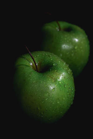 Apple fruit, abstract shadow, black background, green apple, drops of waterの写真素材