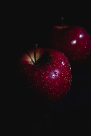 Apple fruit, abstract shadow, black background, red apple, drops of waterの写真素材
