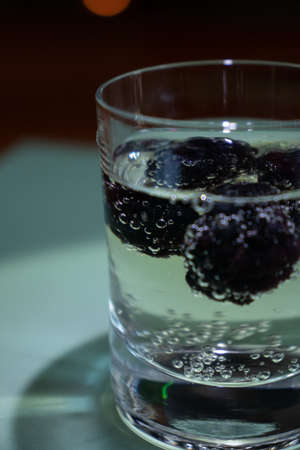 Cranberries fruits in Champagne, transparent glass, turquoise backgroundの写真素材