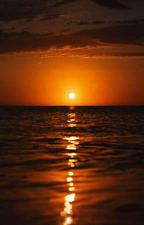 Sunrise from the sea, sun above the water, orange light