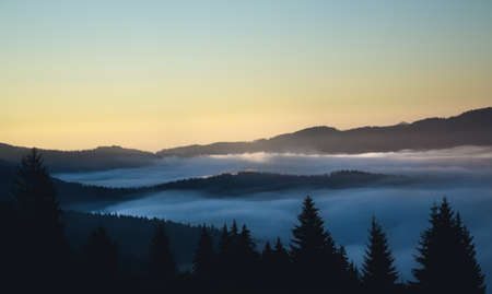 Over the clouds view, mountains in the background, sun rising time