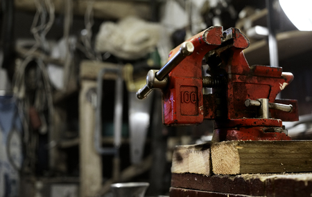 Red vice. Greased and dirty. In background out of focus workshop interiorの写真素材
