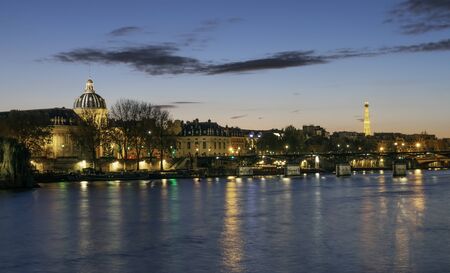 Paris, France - November 05, 2019: Bank of Seine River in Paris in the evening. Among buildings there is dome of French Institute and in distance Eiffel Towerのeditorial素材