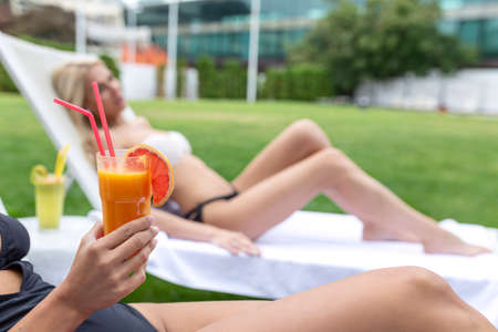 Two women friends at spa resort spending Summer vacation with a cocktail.の写真素材