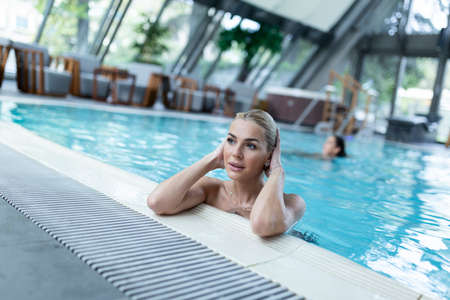 Young beautiful woman enjoying in hot tub while spending relaxing day at health spa.