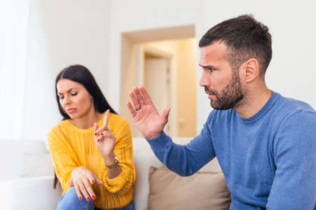 Portrait of two attractive sad worried nervous people married spouses husband wife breaking up having fight guy accusing dumping lady in white light interior roomの写真素材