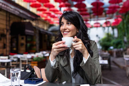 Beautiful young woman with cup of coffee. Woman enjoys fresh coffee in the morning with sunrise at...