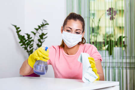 Woman with protective glove and facial mask.Health protection. Hands with yellow gloves.She...
