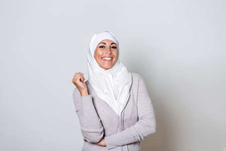 Portrait of pretty young Asian Muslim woman in head scarf smile. Pearl From The East. Smiling Muslim Woman Wearing Hijab. Modern, Stylish and Happy Muslim Woman Wearing a Headscarfの写真素材