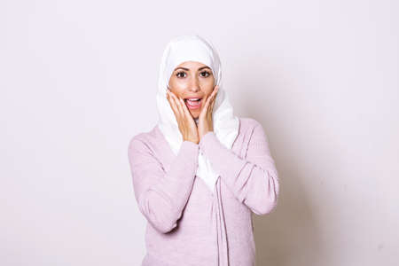 Beautiful muslim woman wearing hijab celebrating for good news. Beautiful young Muslim woman wearing a hijab on her headの写真素材