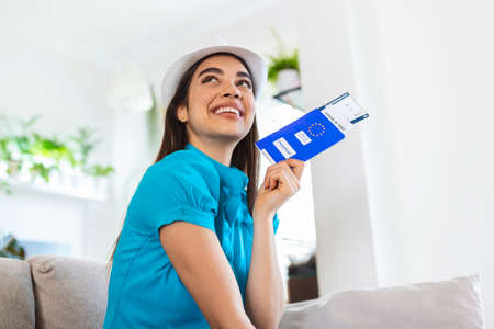 Woman is preparing for travel during covid-19 pandemic. Holding passport, ticket and negative...
