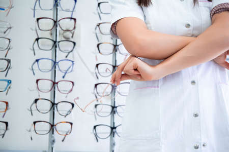 Cropped image of attractive young female doctor in ophthalmology clinic. Doctor ophthalmologist is...