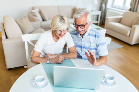 Senior couple is talking online via video connection on the laptop. Having nice time withfriends and family via video call.の写真素材