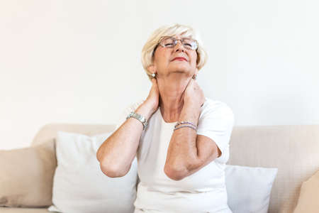 Senior woman feeling exhausted and suffering from neck pain, Health concept. Sad senior lady with neckache. Senior woman with chronic pain syndrome fibromyalgia suffering from acute neckaches.の写真素材