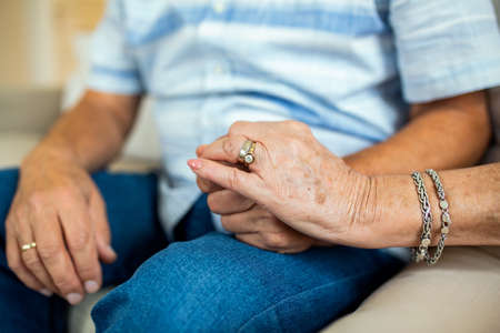 Close up of mature old husband and wife hold hands show love and care. Senior couple holding hands...