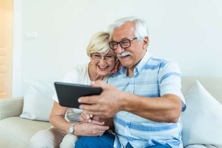 Cheerful senior people websurfing on internet with tablet,family, technology, age and people concept...
