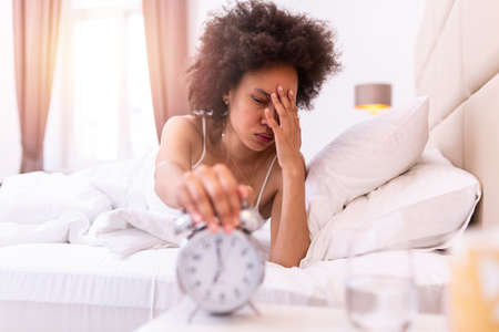 Young beautiful black woman waking up with headache, sad, migraine stressed, crying, disappointed...