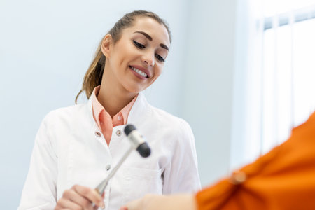 Neurological examination. The neurologist testing reflexes on a female patient using a hammer. Diagnostic, healthcare, medical serviceの写真素材