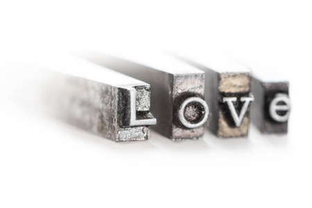 The word  love  in letterpress type on withe background - Macro fom the sideの写真素材