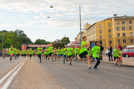 STOCKHOLM - AUG, 17  Just after the start in one of many groups for children in the Midnight Run for children  Lilla Midnattsloppet  event, a group of excited children running  Aug 17, 2013 in Stockholm, Swedenのeditorial素材