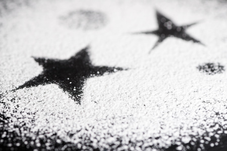 Black star made with white powdered sugar short depth of field