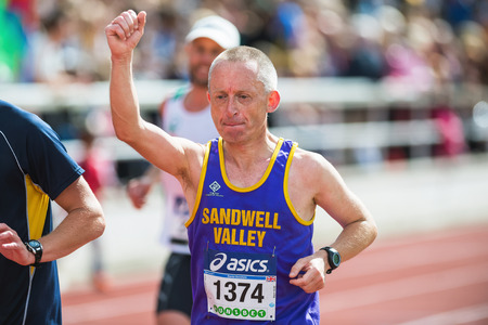 STOCKHOLM - MAY 31: Man rising his hand on the final stretch at Stockholm Stadion in ASICS Stockholm Marathon 2014. May 31, 2014 in Stockholm, Sweden.のeditorial素材