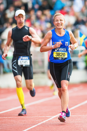 STOCKHOLM - MAY 31: Woman running the final stretch at Stockholm Stadion in ASICS Stockholm Marathon 2014. May 31, 2014 in Stockholm, Sweden.のeditorial素材