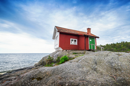 NORRTALJE, STOCKHOLM - JUNE 11: Albert Engstroms seaside cabin. June 11, 2014 in Stockholm, Norrtalje. Painted in white towards the sea as a landmark and red as traditional colors.のeditorial素材