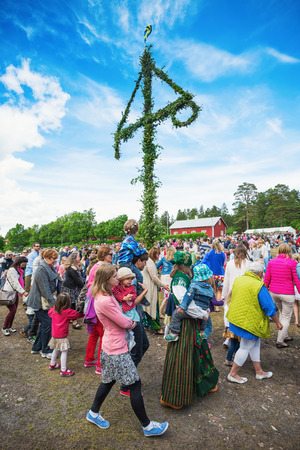 SINGO, NORRTALJE - JUNE 20: Traditional swedish midsummers day with people dancing around the midsummer pole or maypole. June 20, 2014 in Singo, Sweden.のeditorial素材