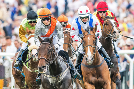 STOCKHOLM - JUNE 6: Closeup of jockeys into last curve at the Nationaldags Galoppen at Gardet. June 6, 2014 in Stockholm, Sweden.のeditorial素材