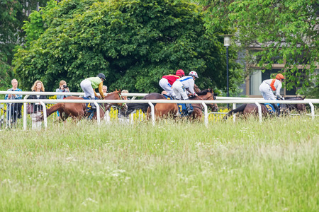 STOCKHOLM - JUNE 6: Riders passing the far side at the Nationaldags Galoppen in Gardet. June 6, 2014 in Stockholm, Sweden.のeditorial素材